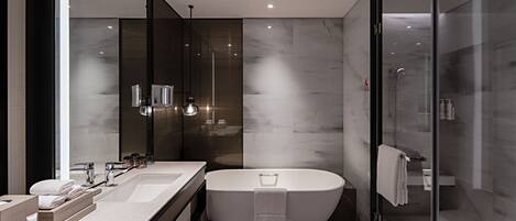 A modern bathroom with a freestanding bathtub, dual sinks, and a glass shower enclosure.