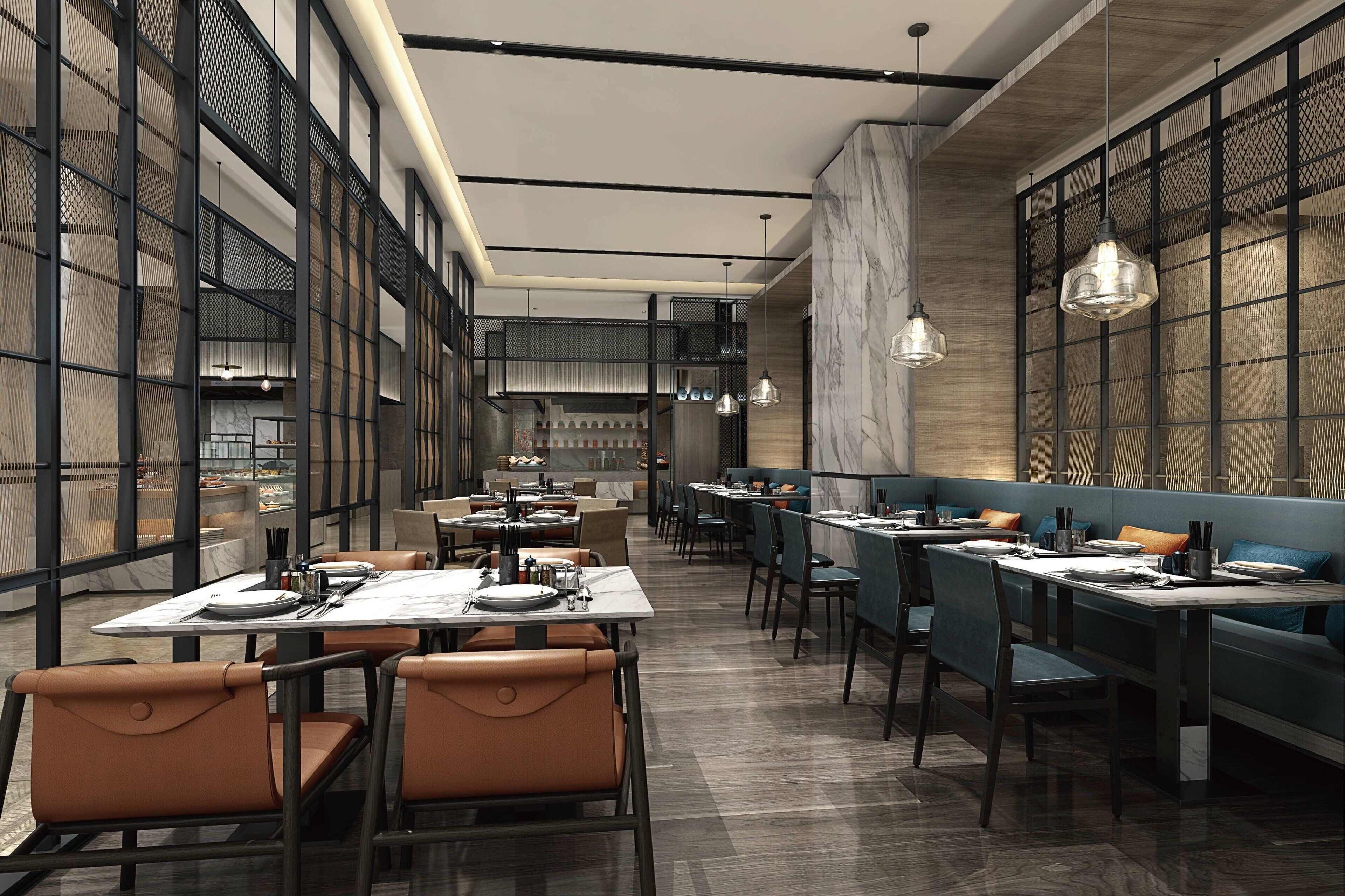 A modern restaurant interior with high ceilings, patterned walls, and a mix of booth and table seating.