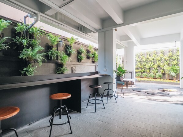 An indoor seating area with a modern bar and potted plants.