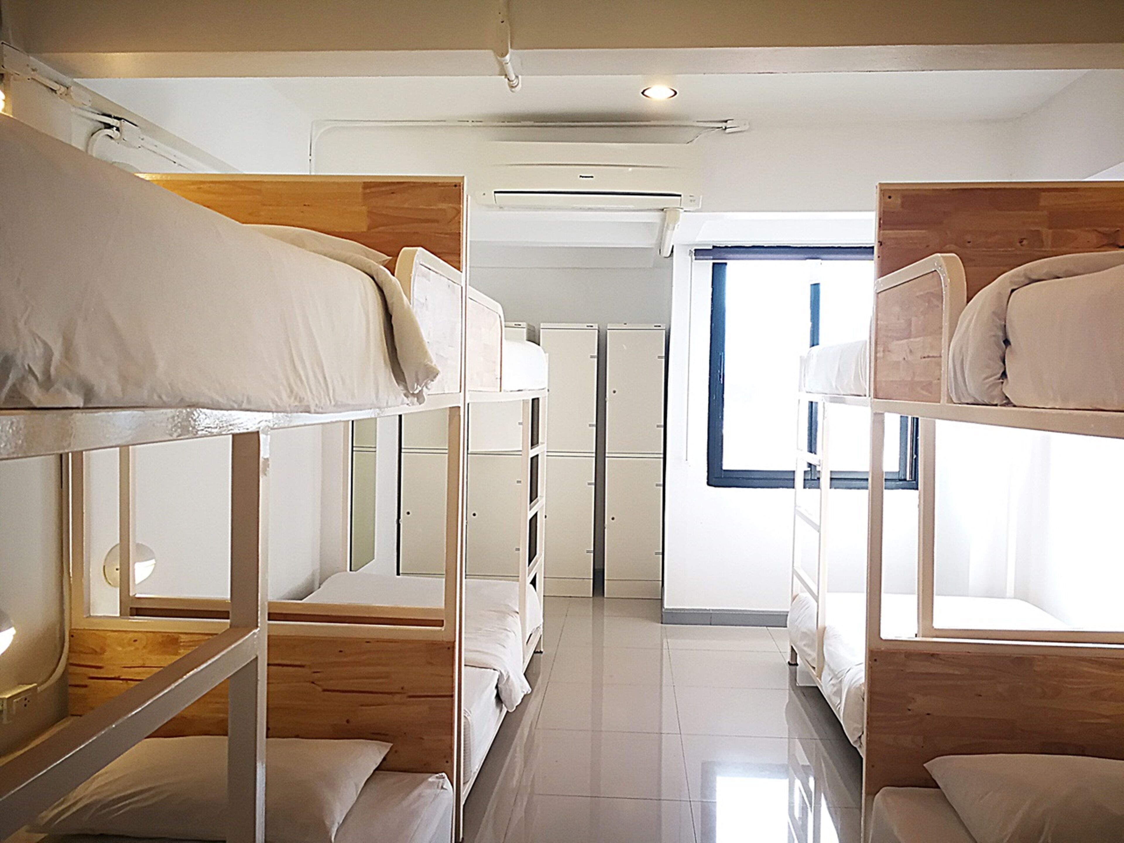 Quarto com beliche, janela, guarda-roupa e ar condicionado.