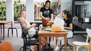 A casual dining area with a wooden table, chairs, and a kitchen in the background.