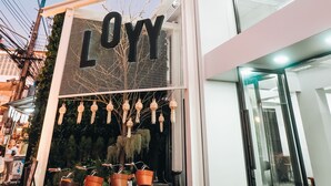 A building with a sign reading "LOYN" and a glass entrance. There are bicycles with baskets outside. - Loyy Hotel - Hostel (Chiang Mai)