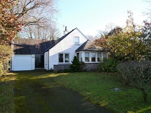 A single-story house with a garage, a front porch, and a lawn.