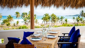A table set for dining with a view of the beach and palm trees. - Selectum Hacienda Punta Cana (Punta Cana)