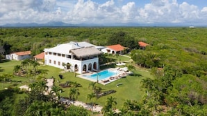 A large white building with a pool and a red-roofed structure in a lush green landscape. - Selectum Hacienda Punta Cana (Punta Cana)