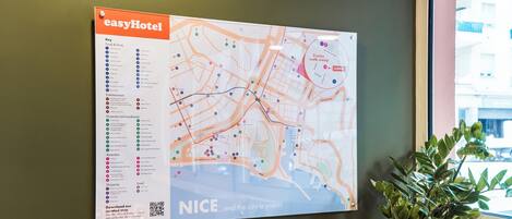 A wall map with a QR code, key for amenities, and a sign for easyHotel.