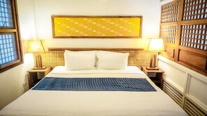 A hotel room with a large bed, two bedside lamps, a patterned headboard, and a decorative wall panel. - Vista del Mar by Cocotel (Zamboanga)