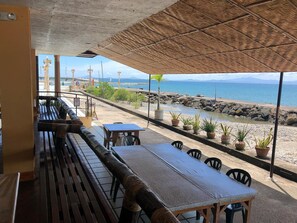Un área de estar al aire libre con vista al mar y a las montañas.