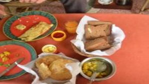 Una mesa con varios platos, incluyendo un guiso de salsa roja, pan y un bol de sopa.