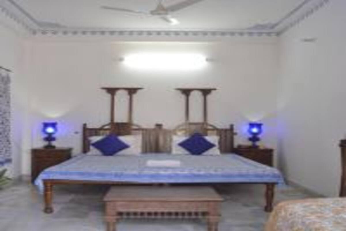A bedroom with a bed, bedside tables, and a ceiling fan.