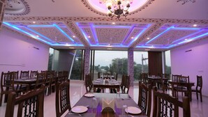 A dining area with a high ceiling, ornate ceiling design, and modern lighting. - Ranbanka Hotel & Restaurant (Udaipur)