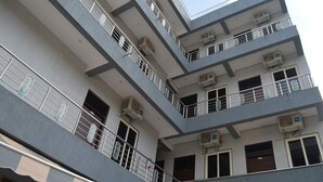 A multi-story building with balconies, air conditioning units, and a visible door. - Ranbanka Hotel & Restaurant (Udaipur)