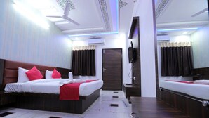 A hotel room with two beds, a TV, and a ceiling fan. - Ranbanka Hotel & Restaurant (Udaipur)