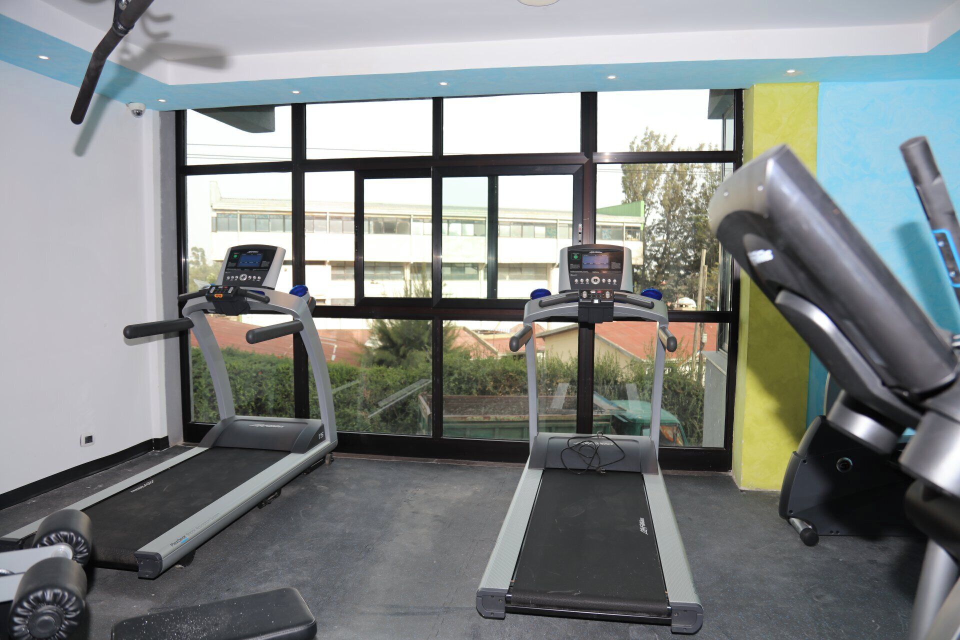 A gym with treadmills, a stationary bike, and a weight bench.