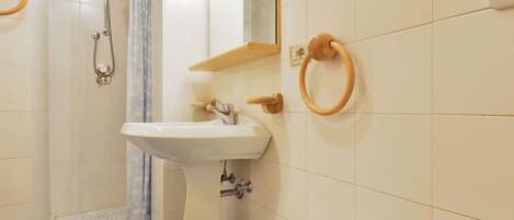 Une salle de bain moderne avec une douche, un lavabo et un miroir.