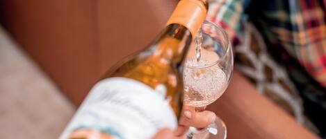 A person pouring a drink from a bottle into a glass.