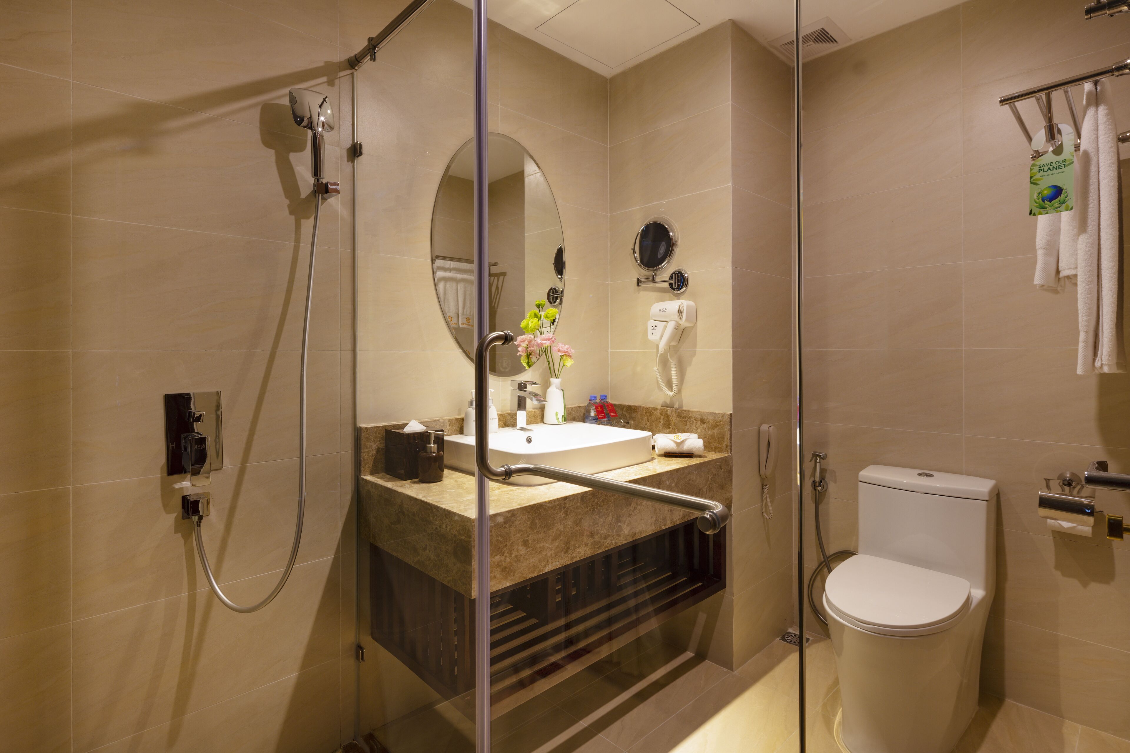 A modern bathroom with a glass-enclosed shower, a sink with a mirror, and a toilet.