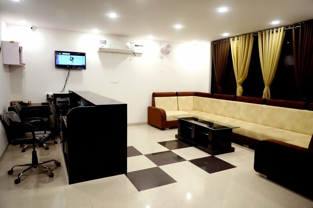 A modern office space with a sofa, a desk, and a computer monitor.