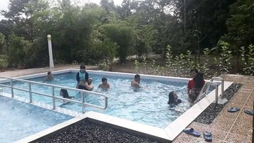 Una piscina rodeada de árboles.