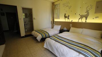 Une chambre d’hôtel avec deux lits, une salle de bain et un mur décoré d’autocollants représentant des animaux.