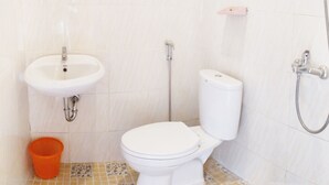 A bathroom with a white sink, toilet, and shower. - Griya Alisha (Sleman)