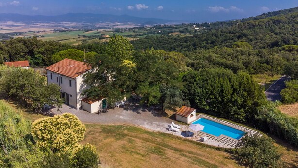 A villa with a swimming pool surrounded by lush greenery and hills in the background. - Nice apartment in villa for 17 people with pool, TV and pets allowed (Rosignano Solvay-castiglioncello)