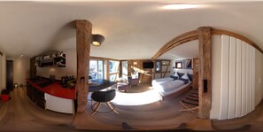 Eine moderne Küche mit einer gewölbten Kochinsel, ein Essbereich mit einem Holztisch und ein gemütliches Schlafzimmer mit einem Bett und einem großen Fenster.