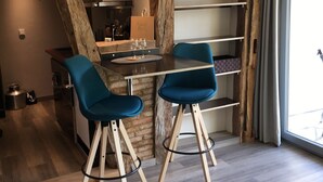 Een moderne keuken met een centraal eiland, twee barkrukken en een eettafel.