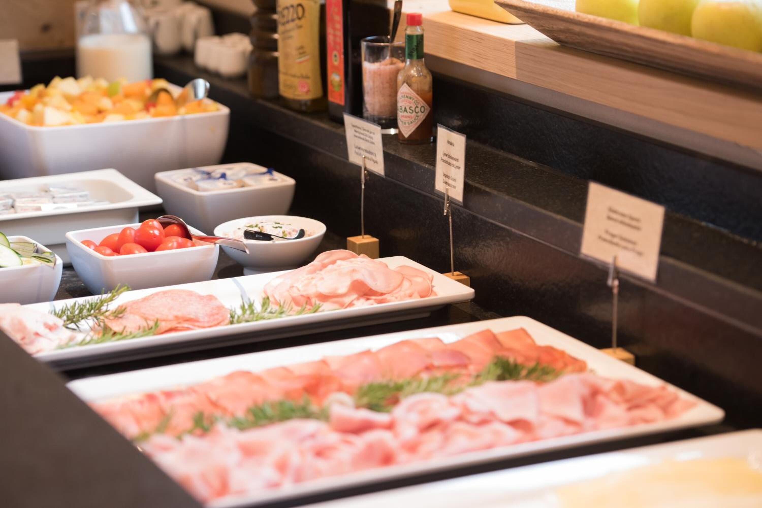 A buffet with various food items including fruits, salads, and meats.