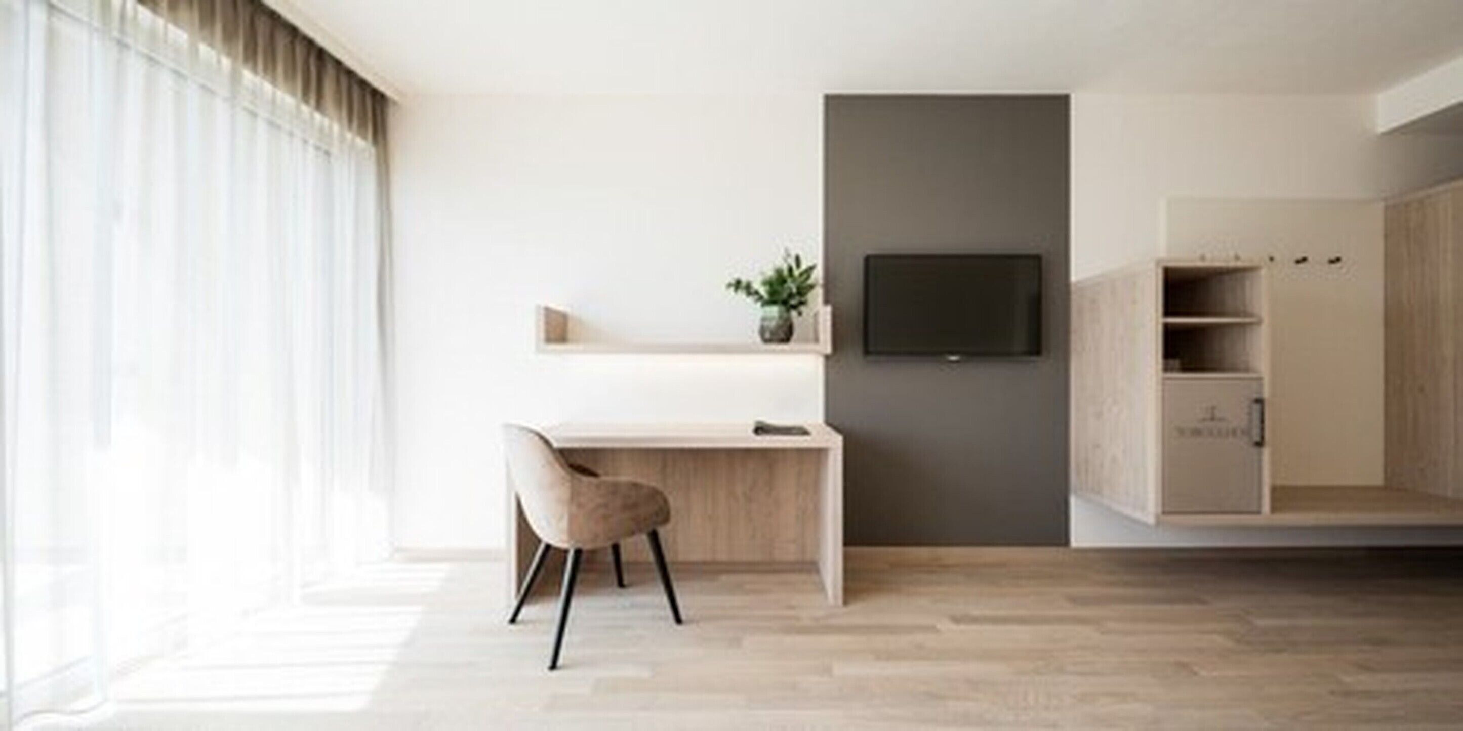 Quarto moderno com escrivaninha, cadeira, televisão e estantes embutidas.