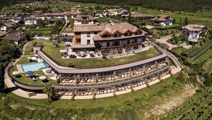 A large resort with a pool, outdoor seating, and a vineyard. - Hotel Torgglhof Kaltern (Caldaro Sulla Strada del Vino)