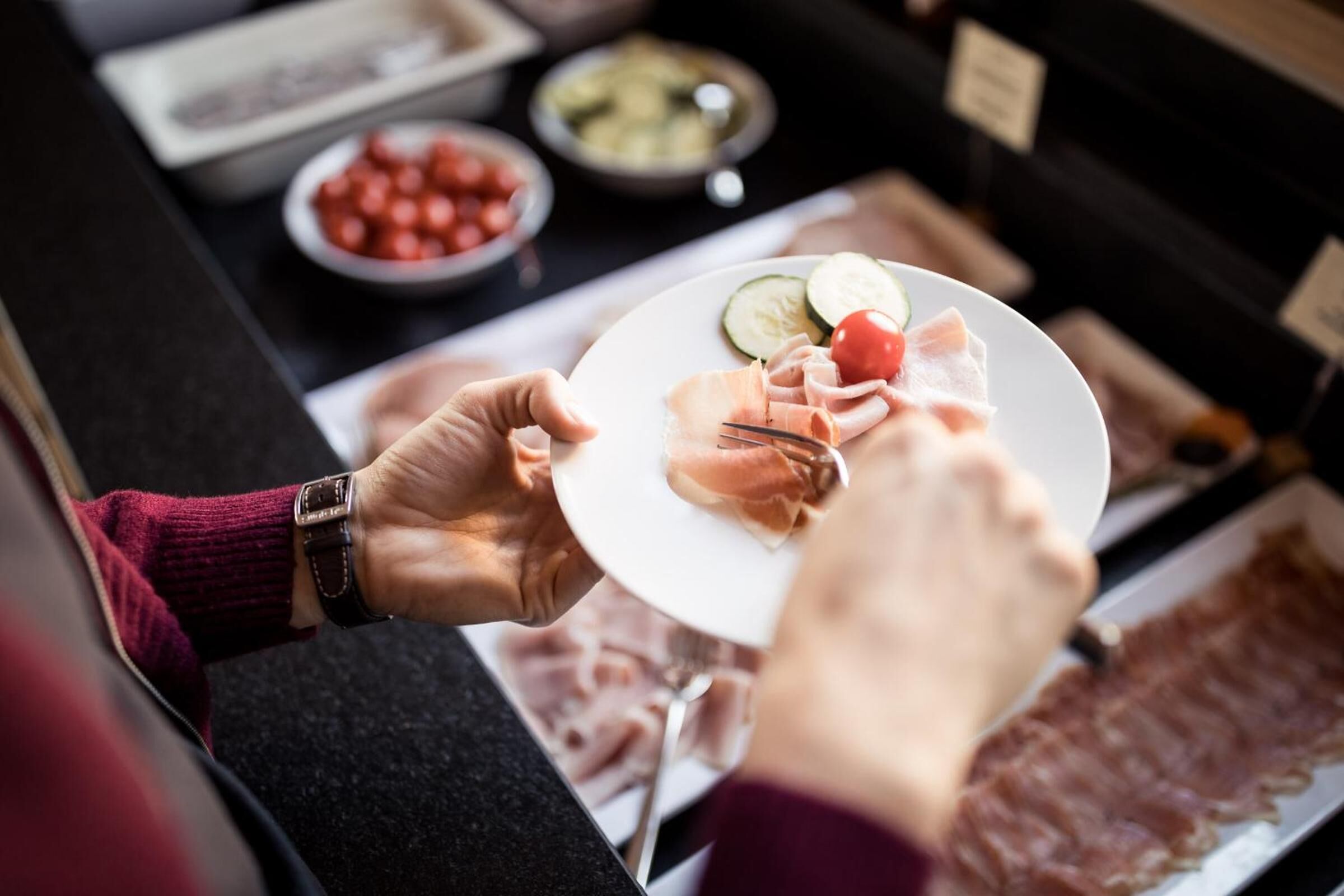 Iemand kiest eten bij een lopend buffet.