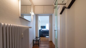 A narrow hallway with a radiator, a red rug, and a bench. - Wonderful view for 4 people 100 m from the main beach (Wangerooge)