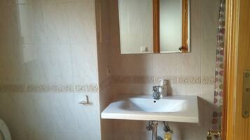 Een bad/douchecombinatie, een haardroger, een bidet, handdoeken