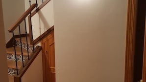 A hallway with a wooden staircase, a light fixture, and a door. - Beautiful duplex in unbeatable location (Segovia)