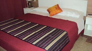 A hotel room with a bed, a nightstand, a lamp, and a red curtain. - Hotel Mirage (Messina)