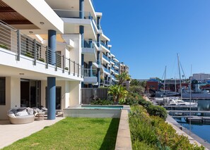 A modern multi-story hotel with balconies, a swimming pool, and a marina with boats. - 005 Palgrave on the Waterfront Marina (Cape Town)