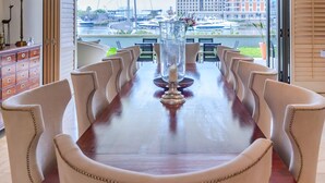 Une salle de conférence avec une longue table, des chaises et une vue sur le paysage urbain, grâce à de grandes fenêtres.