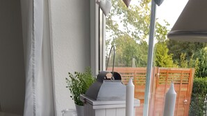 A window with a white radiator, a white lantern, and two white candles on a windowsill. - **** NEW **** Ferienhaus Meerzeit Eckernförde **** NEW ****  (Eckernförde)