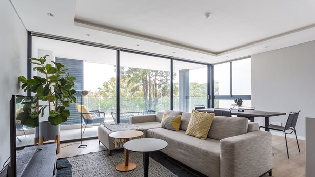 Uma sala de estar moderna com sofá, mesa de centro e área de jantar.