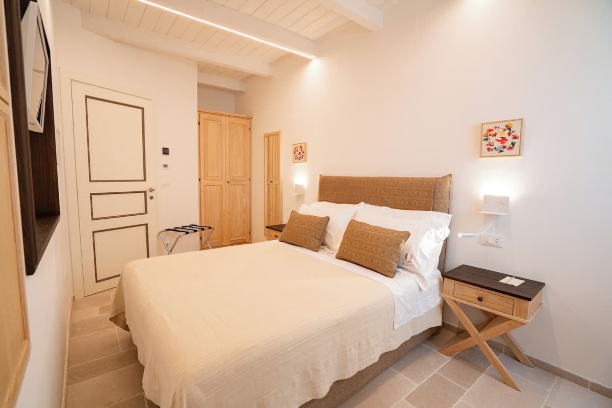 Een slaapkamer met een bed, nachtkastjes, een kledingkast en een spiegel.