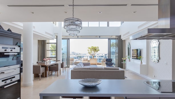 A modern kitchen with a dining area, a chandelier, and a view of the city. - Penthouse 702 Kylemore B (Stellenbosch)