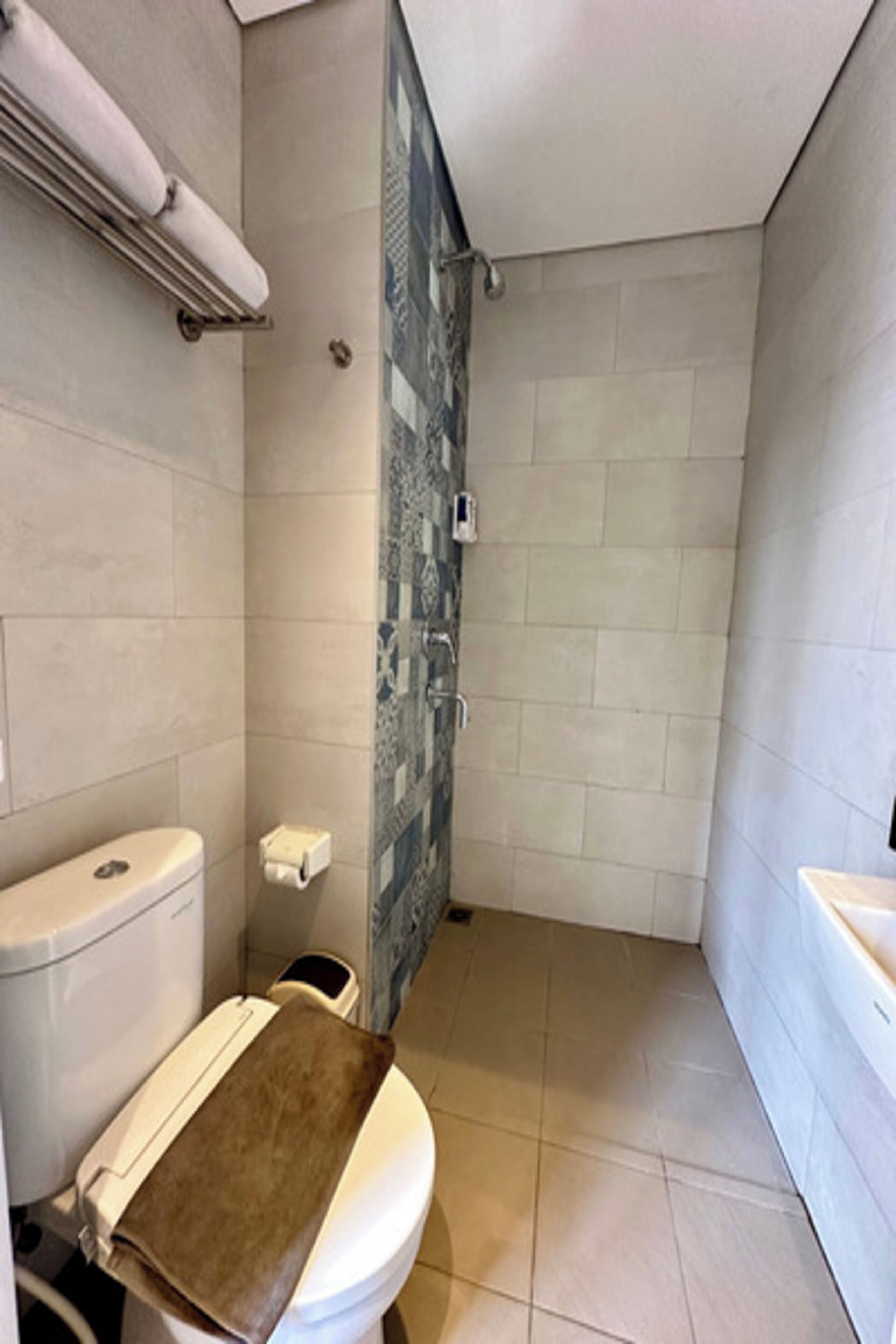 Une salle de bain équipée de toilettes, d’une douche et d’un lavabo.
