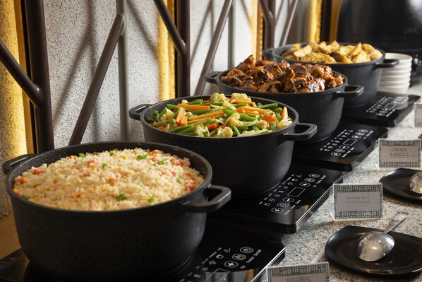 A buffet with various dishes including rice, vegetables, and meat.