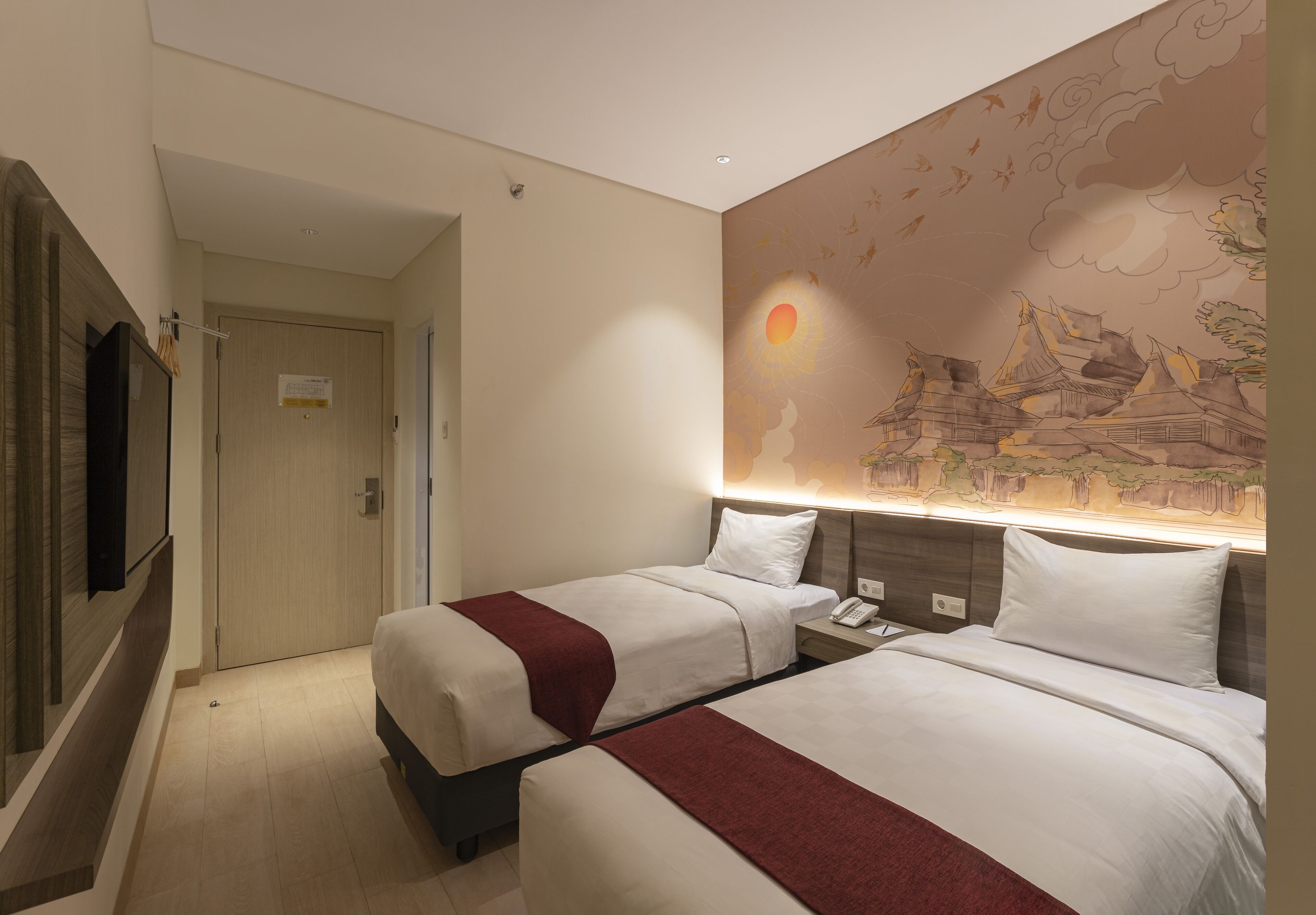 Habitación de hotel con dos camas, un televisor y un mural de escena tradicional.