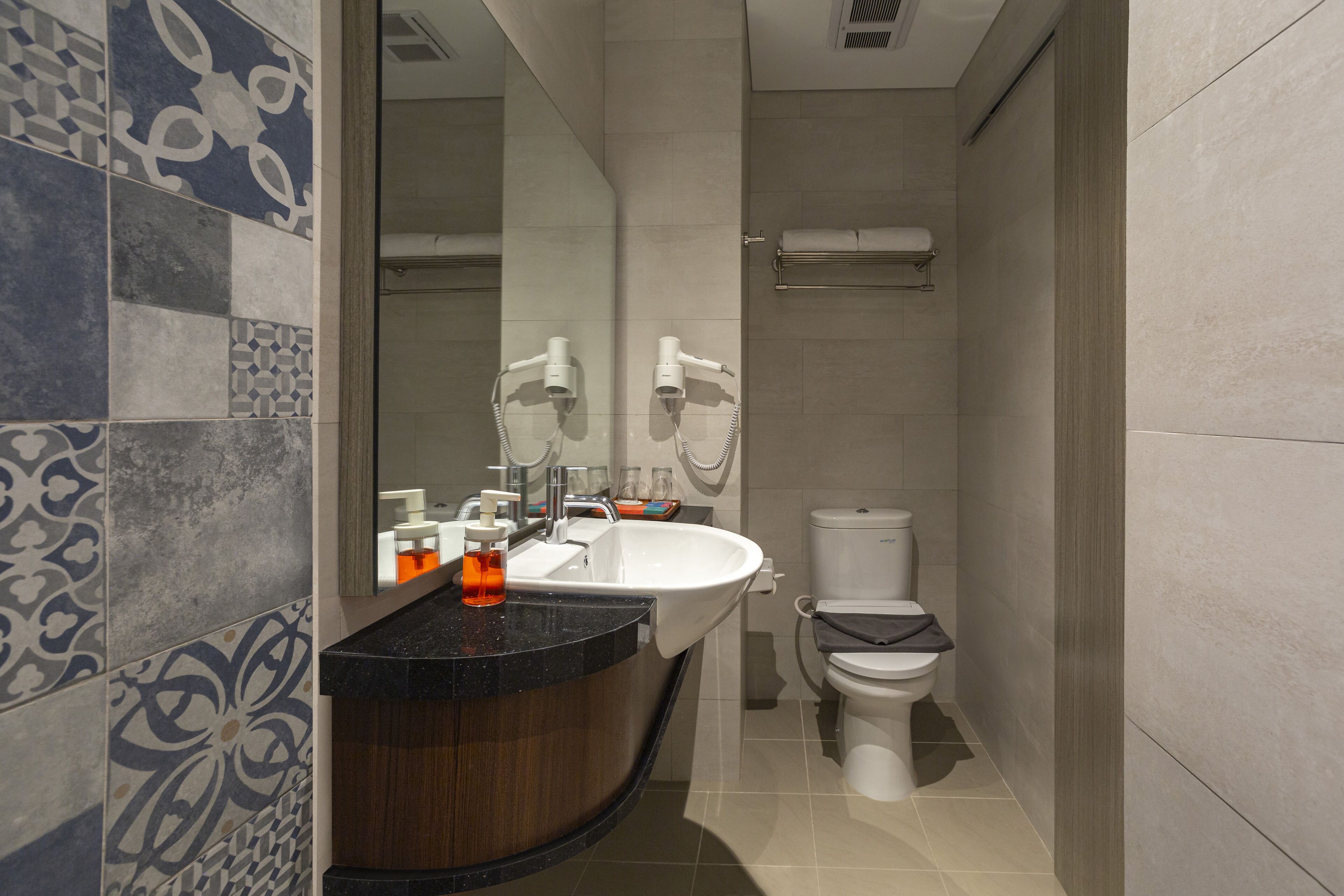 A modern bathroom with a curved vanity, a white sink, and a toilet.
