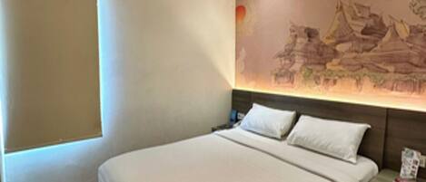 A modern hotel room with a large bed, a nightstand, and a wall mural.