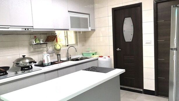 Une cuisine moderne avec des armoires blanches, un four à micro-ondes, une cuisinière et un évier.