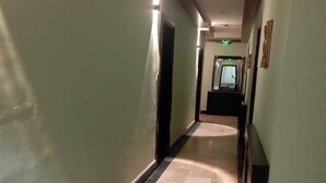 A long, narrow hallway with a tiled floor and walls painted in a light color. - Seleen Hotel Suites (Amman)