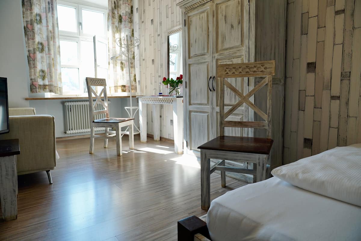 A room with a bed, a desk, a chair, and a radiator.